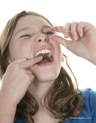 Woman Flossing Before Dental Exam